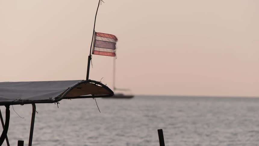 A tattered flag blows in the breeze atop a boat