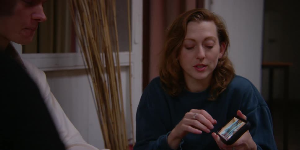 A woman showing a video on her cell phone to others