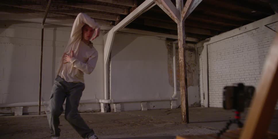 Male dancer dances alone in front of smartphone set on tripod