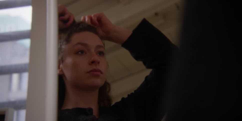 Closeup of a woman tying her hair into a ponytail