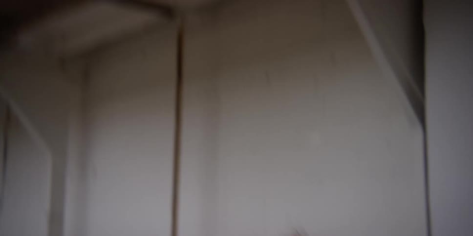 Woman in black clothes dancing alone in a warehouse
