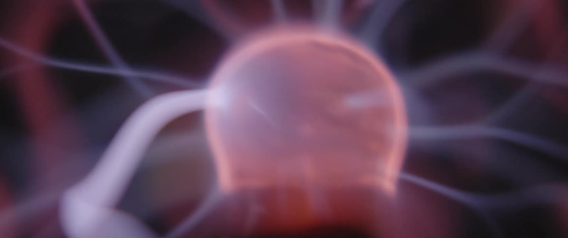 A closeup of a plasma ball with smoke coming out of the top