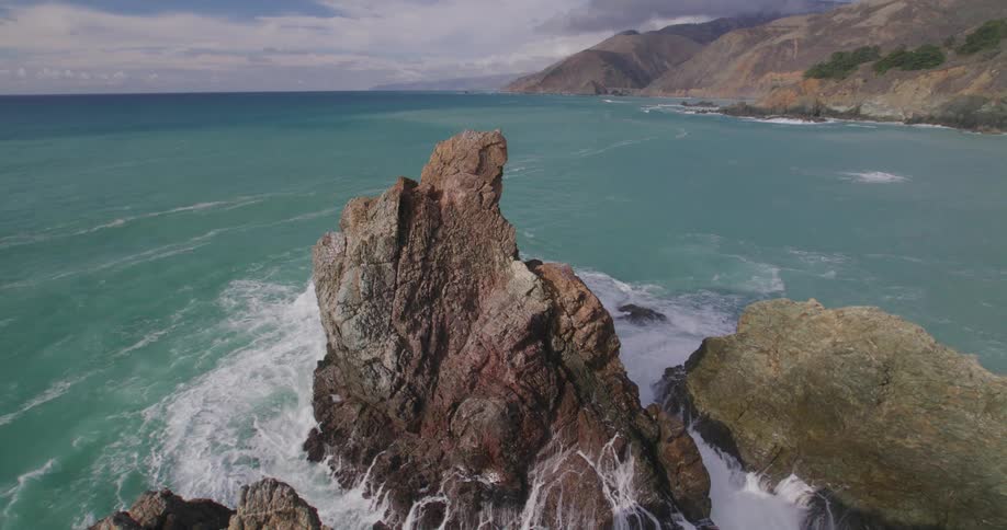 Waves splash against rock formations along the coast