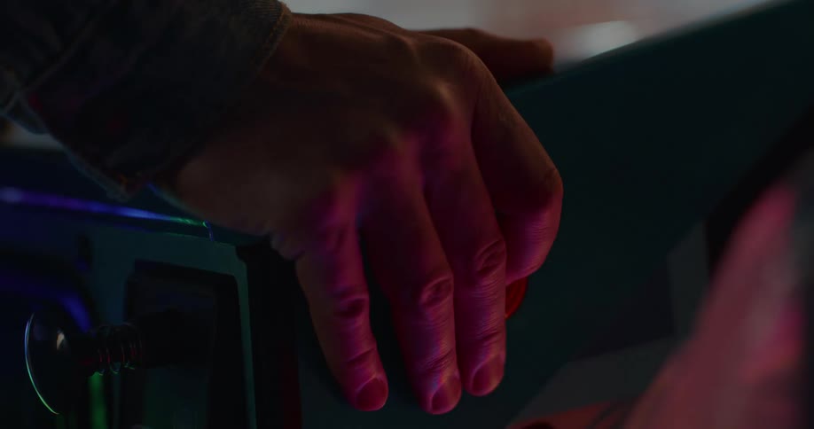 Closeup of a hand pressing a button on a gaming machine