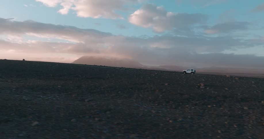 A car driving up a rocky desert road