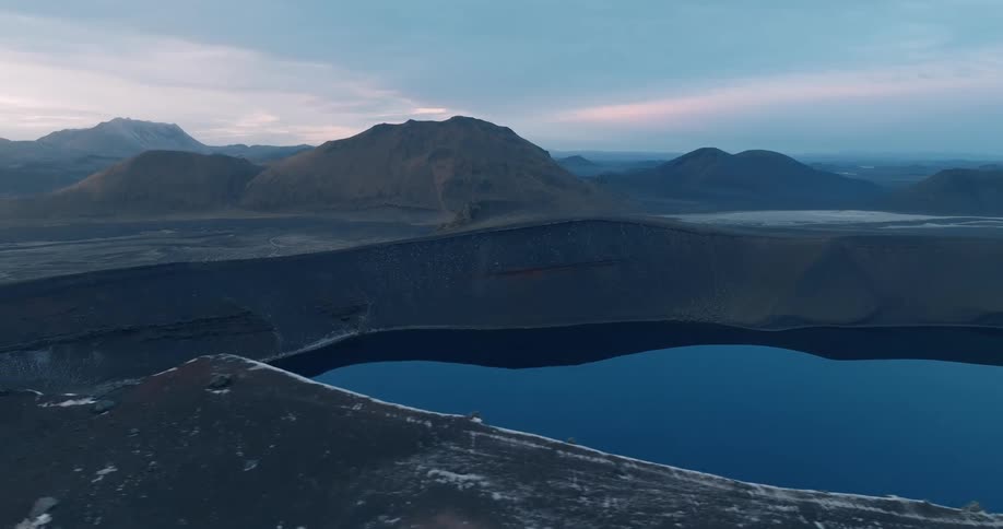 Aerial view of a crater lake next to the mountains at morning