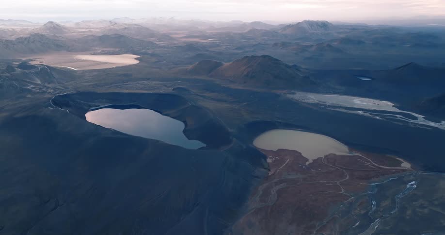 Fog covers mountainous terrain scattered with ponds and lakes