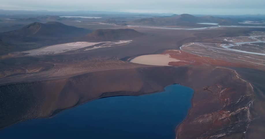 Aerial of a desert lake surrounded by dunes on a sunny day