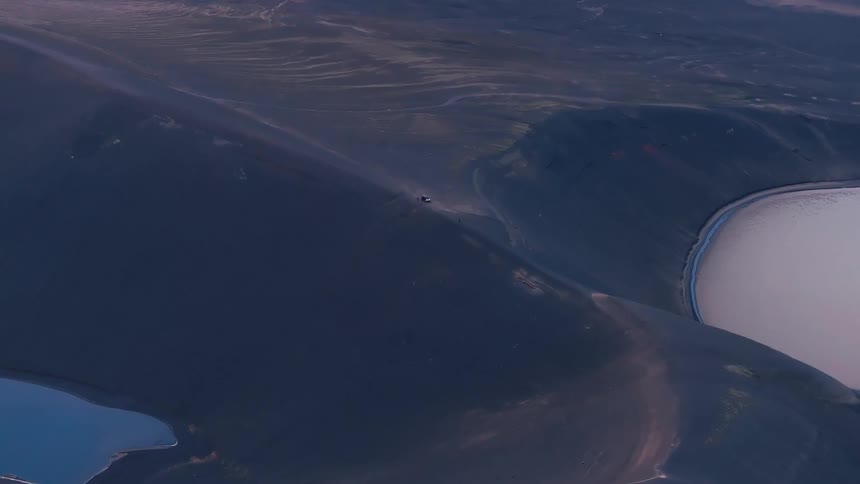 Aerial landscape of craters amid mountains with water