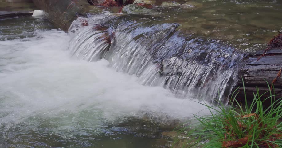 A small waterfall in a lake during the day
