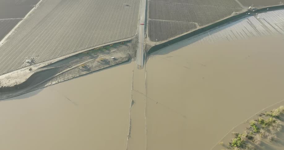 Waterlogged fields on both sides of a road seen from above