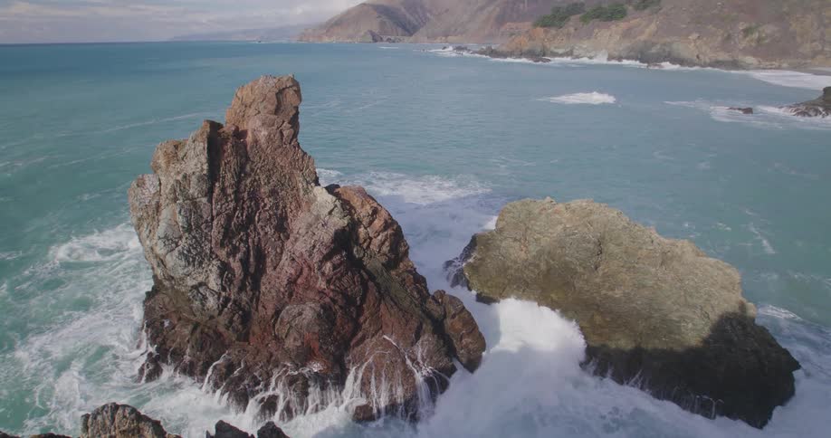 Waves splash against rock formations along the coast