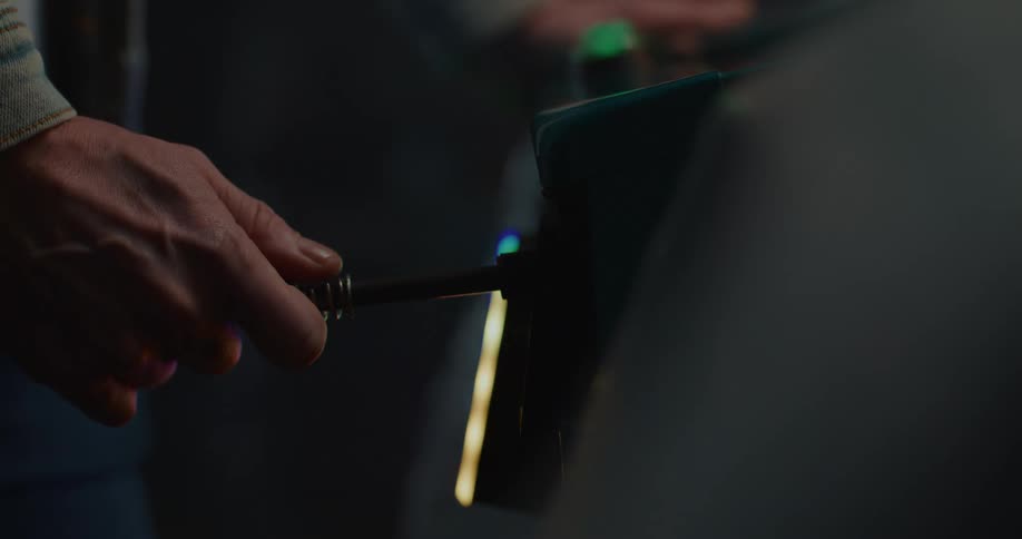 A person pulling a button on an arcade machine