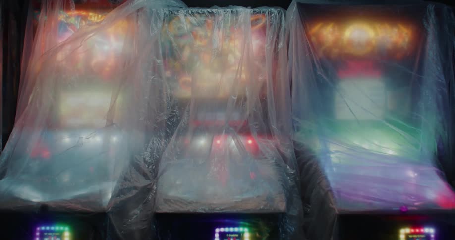 Arcade or pinball machines illuminated under clear plastic covers
