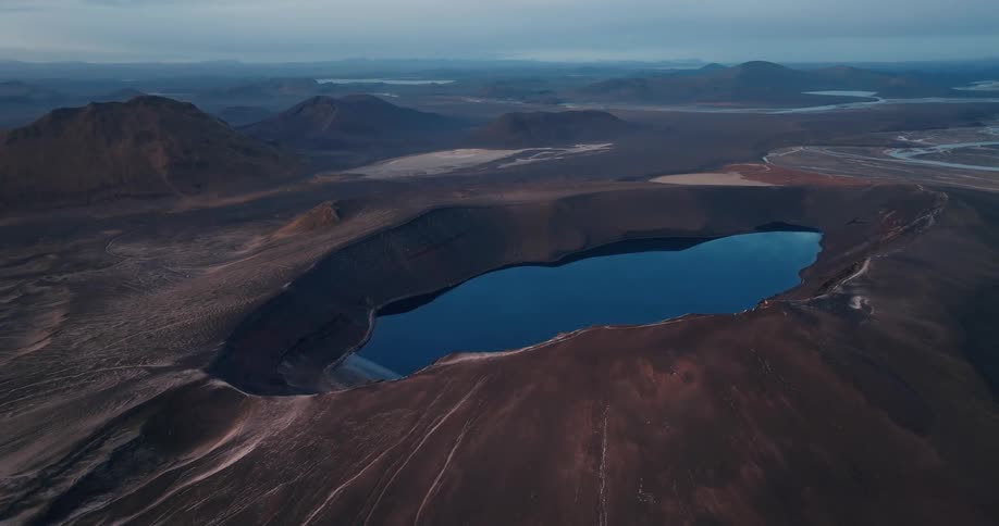 Aerial view of a crater lake on a landscape with mountains
