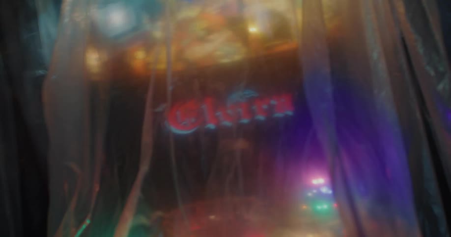 A pinball machine lit up underneath plastic