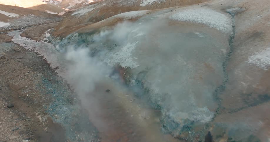 Steam rises from the mountains near the stream