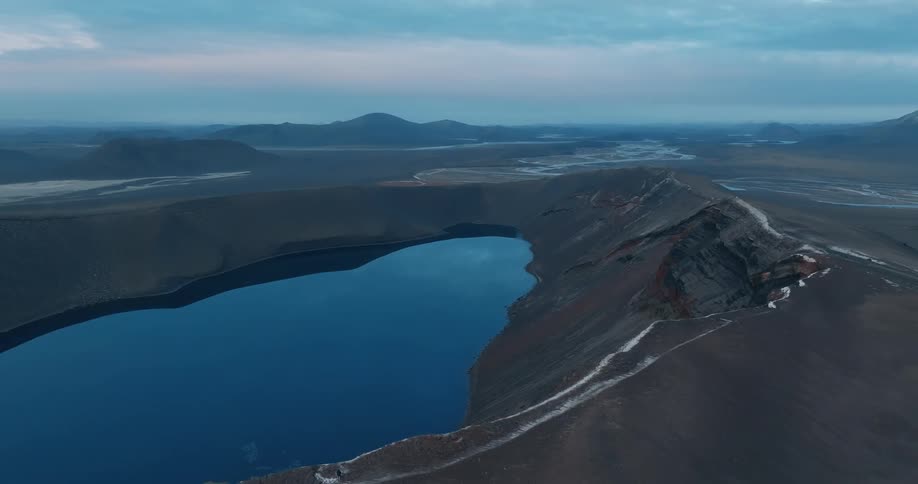 A large blue lake in the middle of some mountains in the highlands