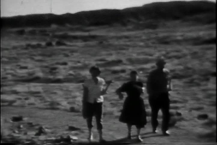 A trio of people walk in a desert