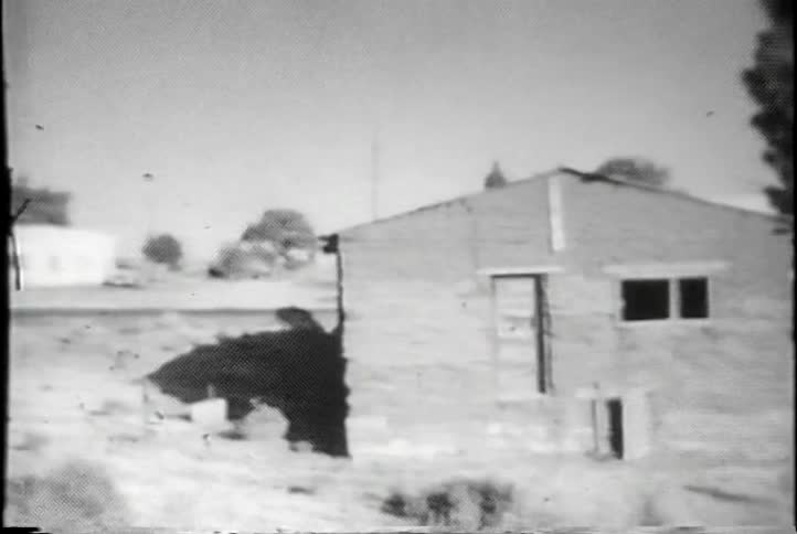 Vintage film of small buildings with some trees around them