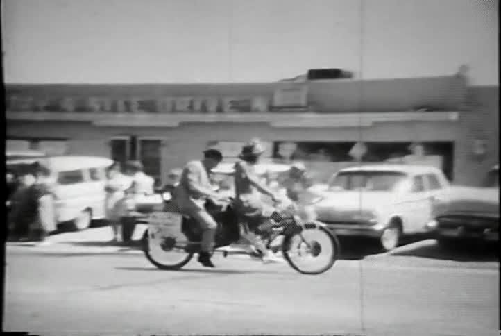 A man and woman ride a two person bicycle