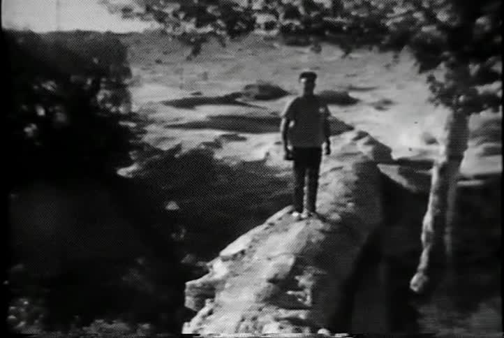A man walks out onto a stone ledge