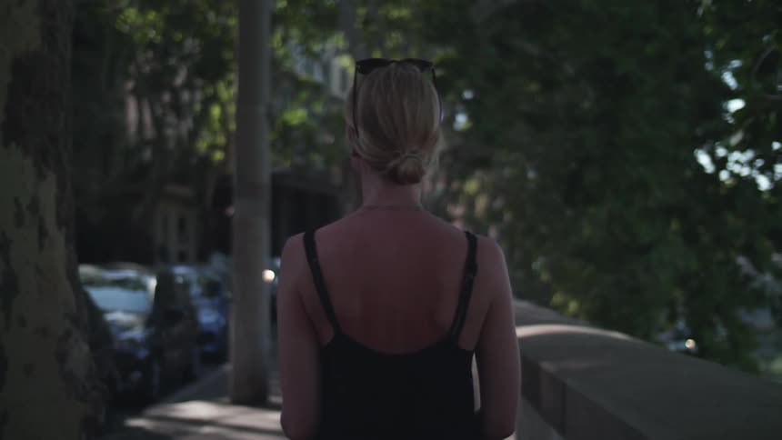 A woman walking through the streets of a neighborhood during the day