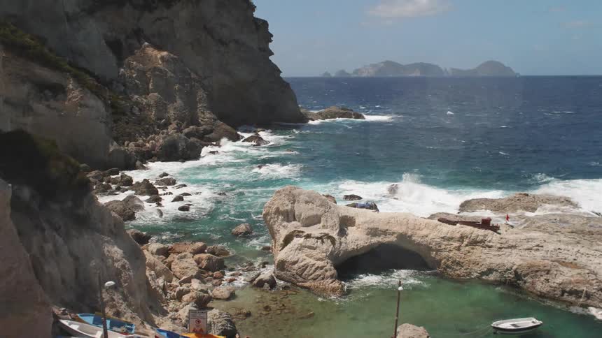 Sea water hitting a rock wall on the coast during the day