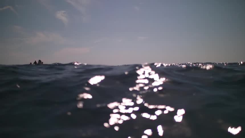 An inflatable motor boat is navigated by a small group of people over the ocean waves
