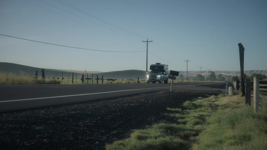A large car driving on an asphalt road in a rural region