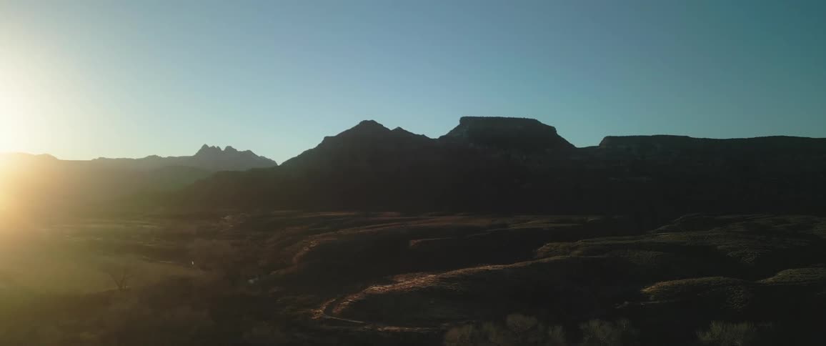 Panorama of mountains and plateaus with sunrise on the horizon