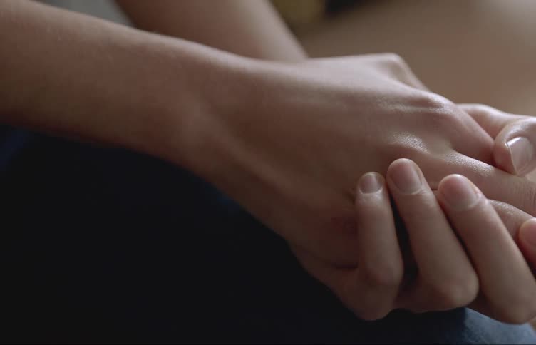 A person rubbing their clasped hands