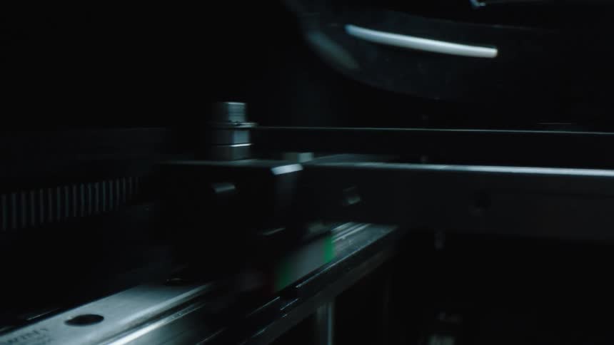 A machine moves a probe back and forth quickly on a rail