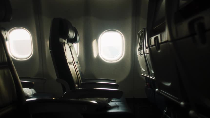 Airplane seats next to an oval window