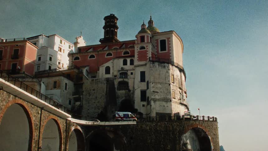 Vehicles crossing an old city bridge during the day