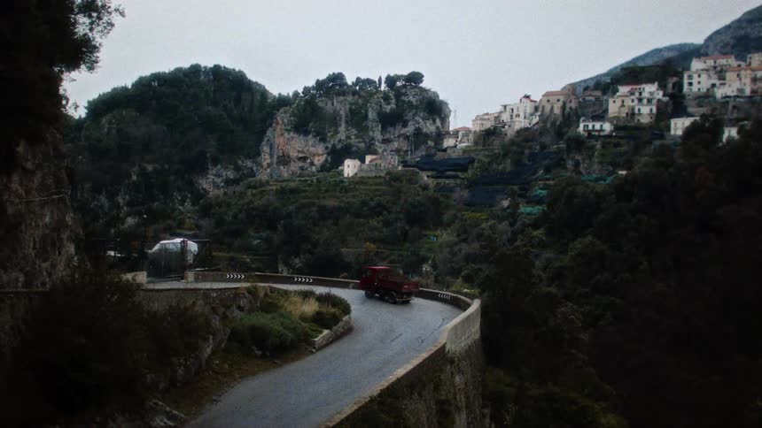 A truck drives on the winding road on the mountain