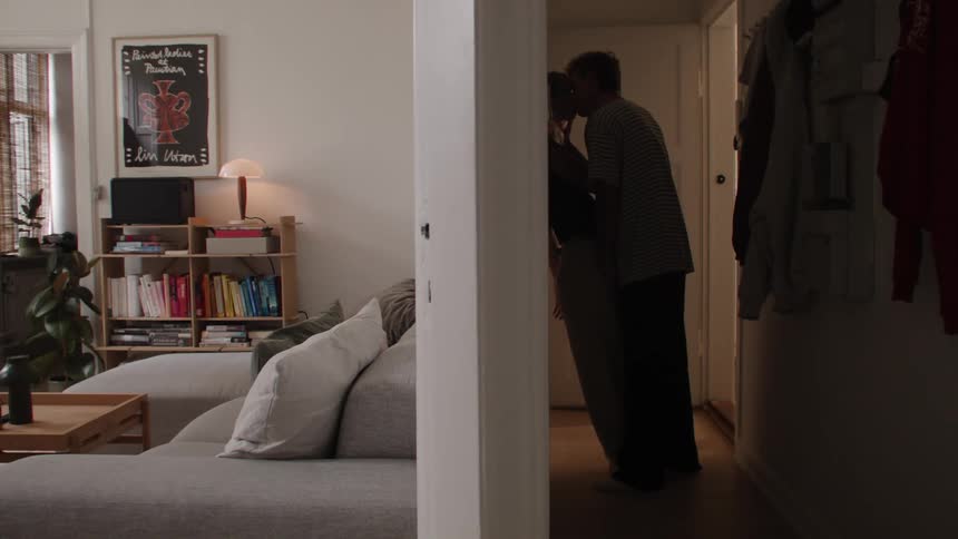 A couple in love kissing in the hallway of their apartment