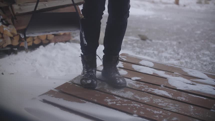 A person carrying firewood during a winter blizzard