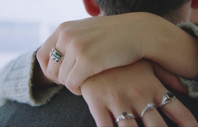 A woman puts her hands around a mans neck as they slow dance