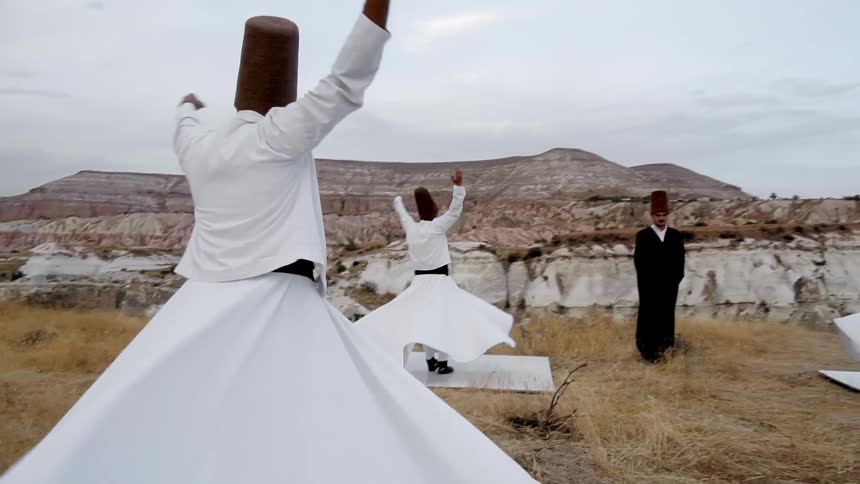 A trio of sufi dervishes twirl in place during their meditative practice