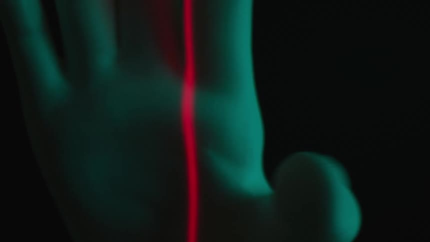 Abstract hand rotating with lights reflecting in a red and laser beam