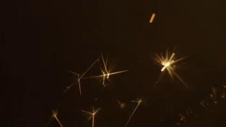 In the darkness countless sparks shoot upward as smoke is released