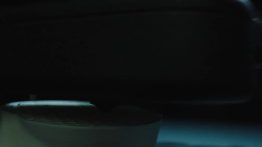 A 3d printer creating a white cylinder in the dark