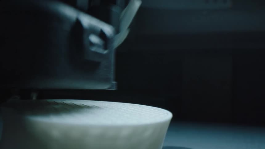 Extreme closeup on a machine drilling holes in a white plastic object
