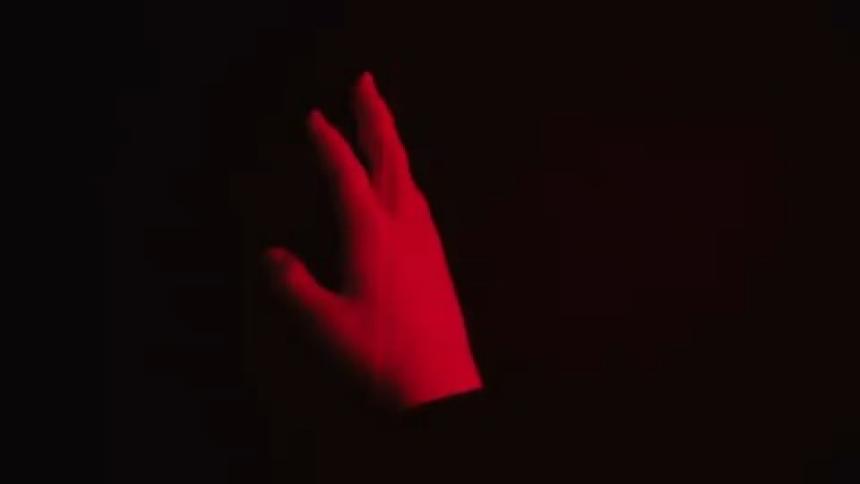 A video of a hand rotating with strobe lights on it