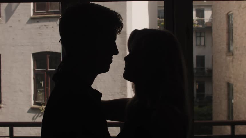 Silhouette of a man and a woman embracing each other romantically