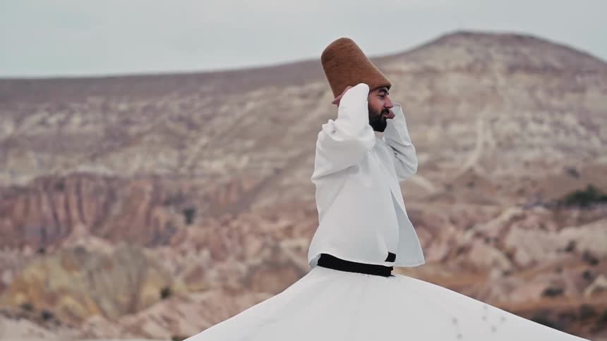 Whirling dervish performs a mountaintop ceremony in cultural attire