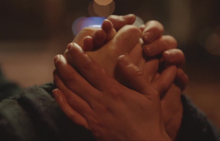 A man and a woman hold hands and caress