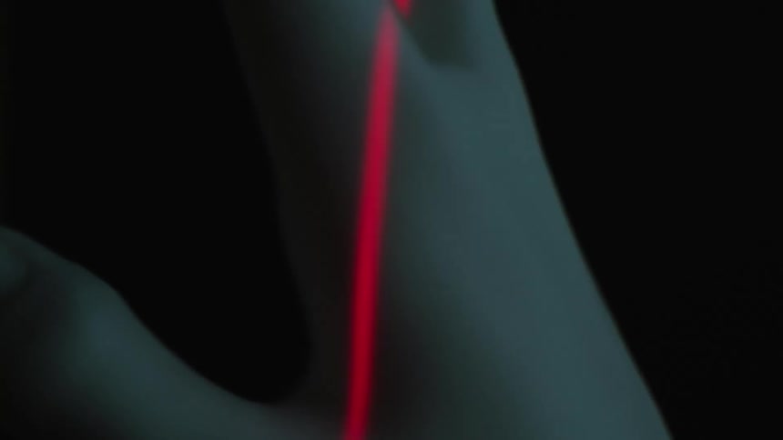 A red laser scanning a fake human hand
