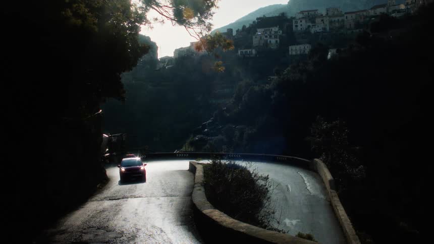 A car drives up a winding road